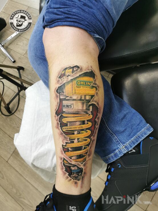 Tattoo Biomechanika in motorization motif and realistic style on the leg