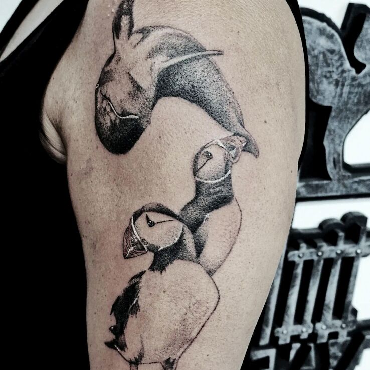 Tatuaż maskonury i delfin w motywie zwierzęta i stylu dotwork na bicepsie