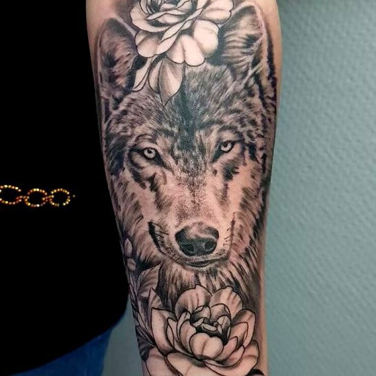 Tatuaż wilczyca w motywie florystyczne i stylu dotwork na przedramieniu