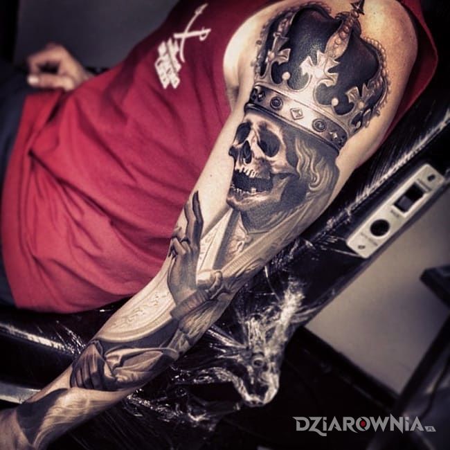 Tatuaż krol szkieletow w motywie czaszki na ramieniu
