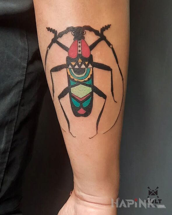Tattoo SKARABEUSZ in insects motif and calligraphy style on the forearm