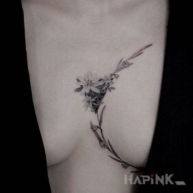 Tattoo Boob wrapped in a flower on the breast motif: black and gray style: realistic