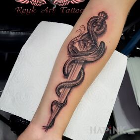 Tattoo Dagger snake on the forearm motif: black and gray style: realistic