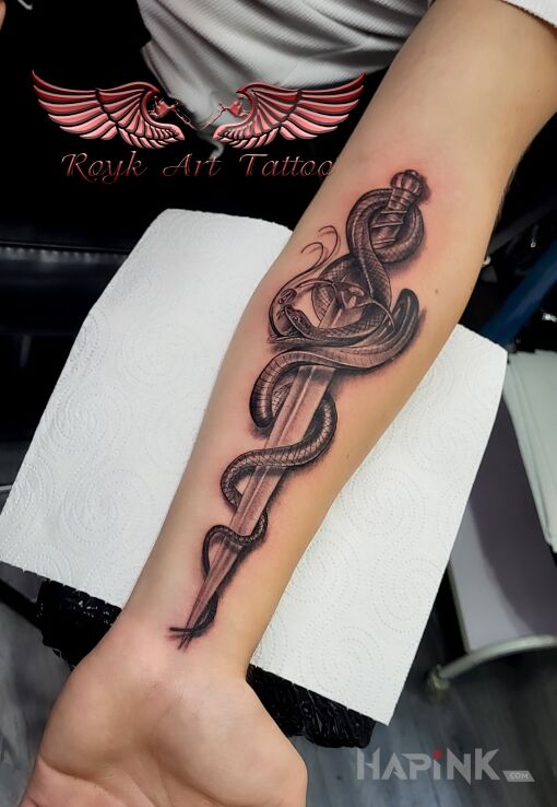Tattoo Wąż sztylet in black and gray motif and realistic style On the arm