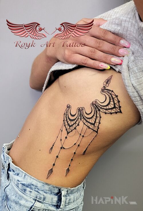 Tattoo Tatuaż kobiecy in black and gray motif and graphic / illustrative style on the ribs