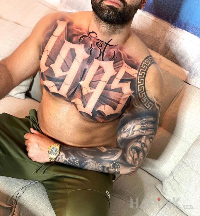 Tattoo 1995 in faces motif and calligraphy style on the upper arm