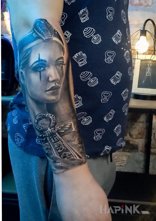 Tattoo Kleopatra in faces motif and realistic style on the forearm