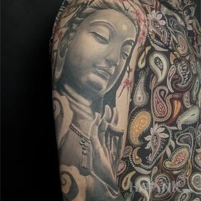 Tattoo Buddha on the upper arm motif: religious style: realistic
