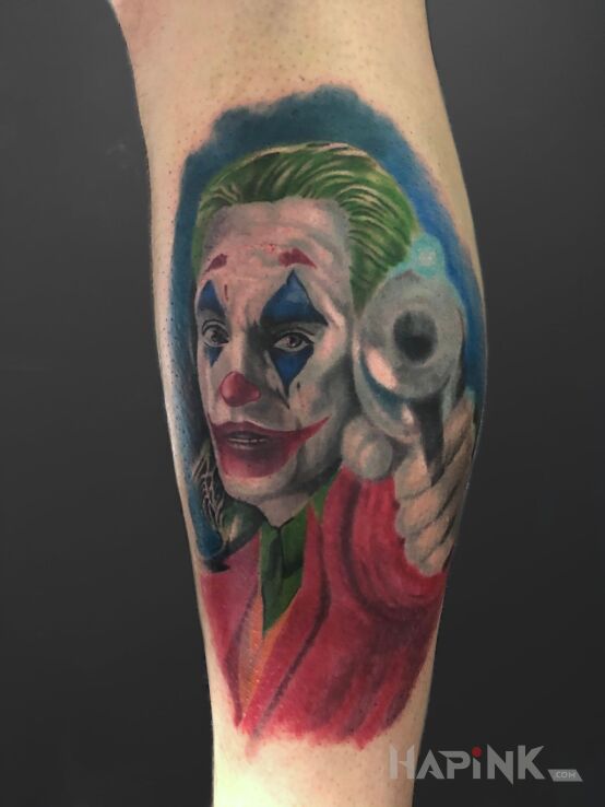 Tattoo Joker in faces motif and realistic style on the leg