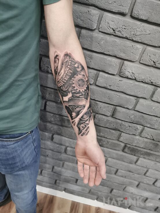 Tattoo Biomechanika in ripped skin motif and realistic style On the arm