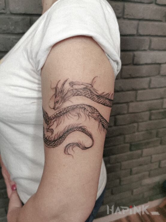 Tattoo Fanka smoków in dragons motif and graphic / illustrative style On the arm