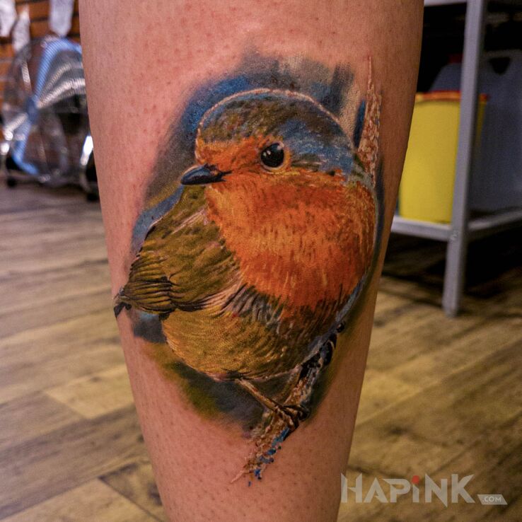 Tattoo Ptaszek in colorful motif and realistic style on the calf