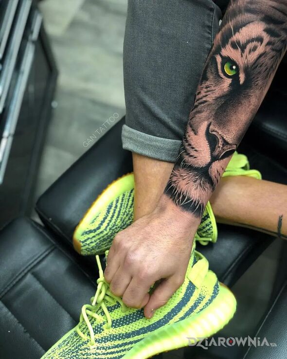 Tatuaż tygrys z zielonym okiem w motywie zwierzęta i stylu realistyczne na przedramieniu
