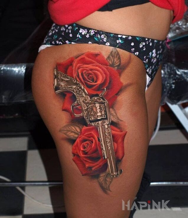 Tattoo Rewolwer in flowers motif and realistic style on the leg