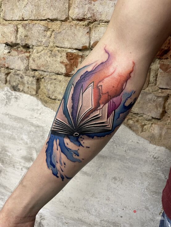 Tattoo Kolorowa Książka Rafała in colorful motif and Watercolor style on the forearm