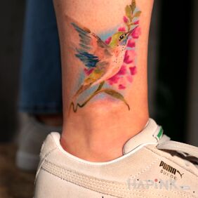 Tattoo Colorful hummingbird on the leg motif: animals style: realistic