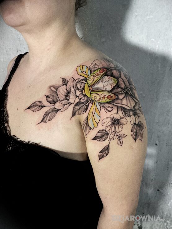 Tatuaż kolorowy żuczek na kwiatkach w motywie florystyczne i stylu graficzne / ilustracyjne na ramieniu