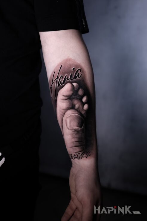 Tattoo Mała stópka in lettering motif and realistic style on the forearm