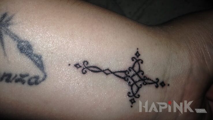 Tattoo KRZYZ in religious motif on the wrist