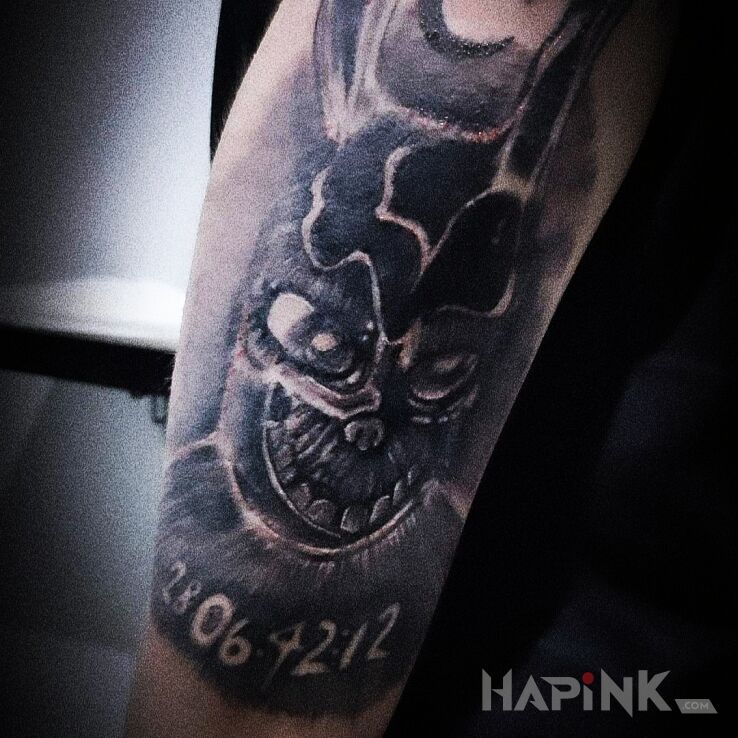 Tattoo Krolik donnie darko in black and gray motif and realistic style On the arm