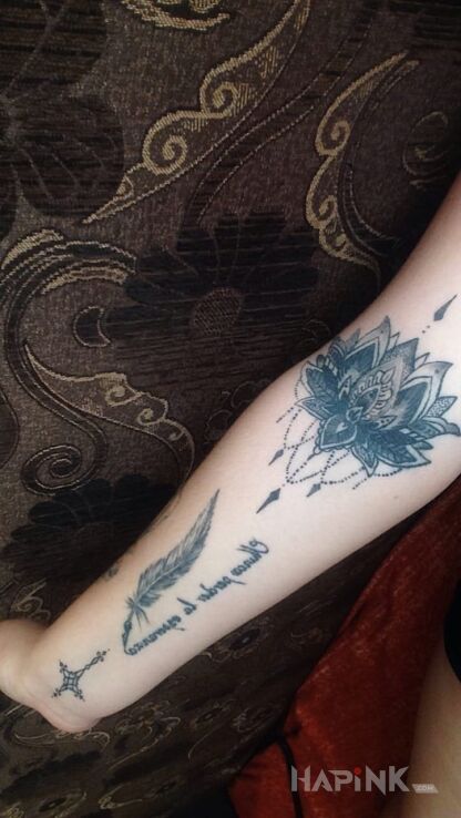 Tattoo Kwiat lotosu,piorko z napisem, krzyzyk in flowers motif on the wrist