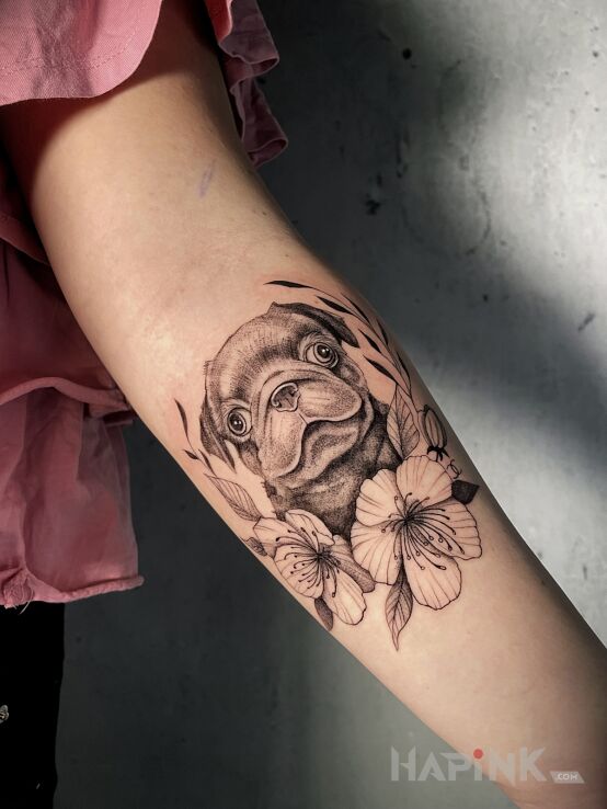 Tattoo Mops w kwiatach in black and gray motif and realistic style On the arm