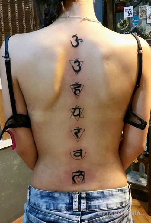 Tatuaż czakry w motywie napisy na plecach