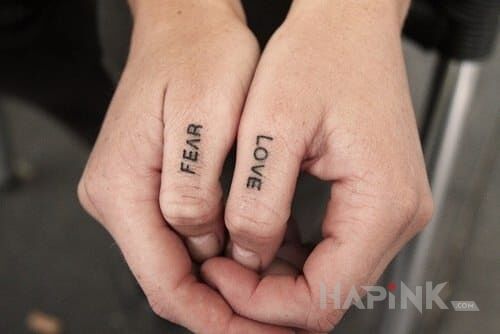 Tattoo Fear / Love in lettering motif on the fingers