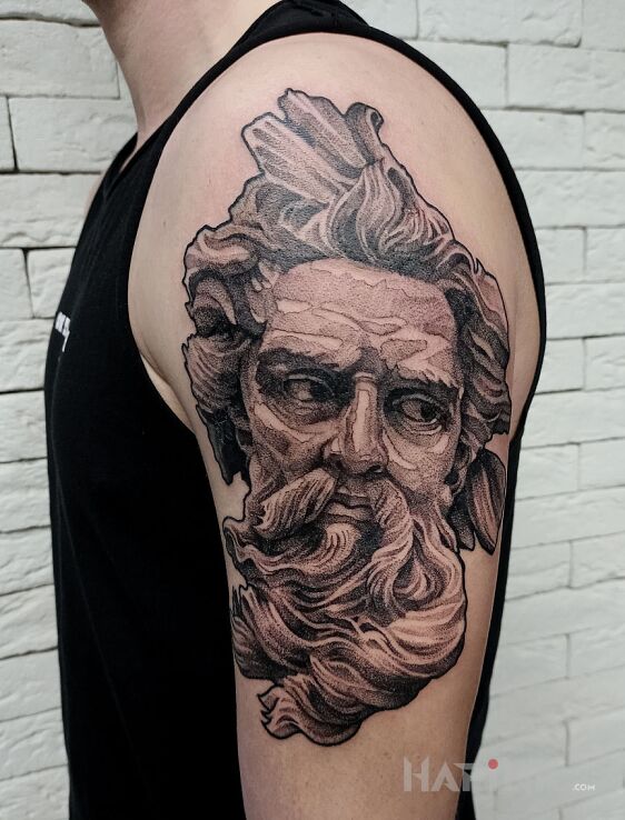 Tattoo Posejdon in faces motif and graphic / illustrative style on the upper arm