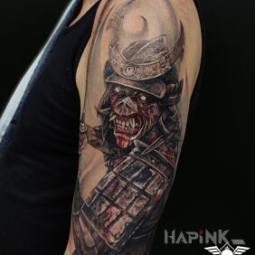 Tattoo Iron Maiden on the upper arm motif: black and gray style: realistic