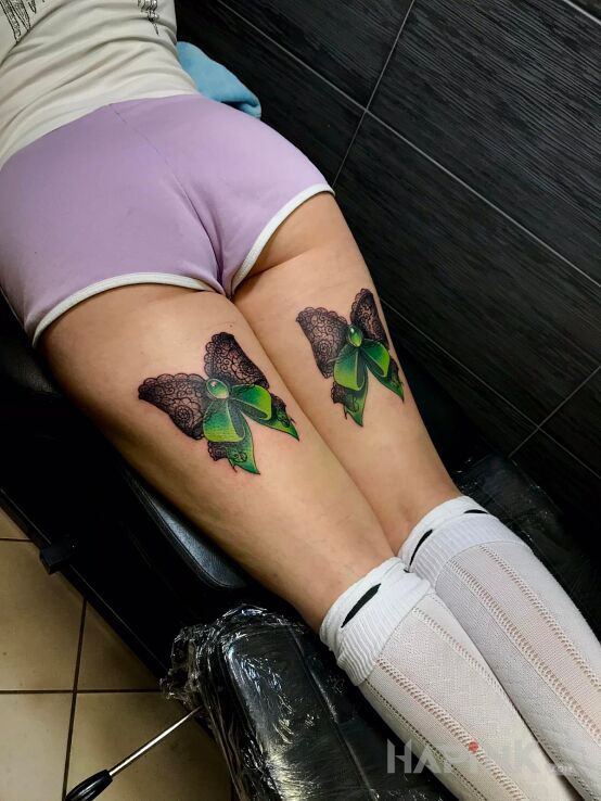Tattoo Kokardki in colorful motif and graphic / illustrative style on the thigh