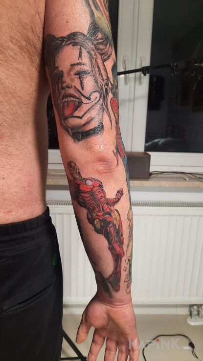 Tattoo Iron Man in colorful motif and cartoon / comic book style on the forearm