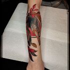 Tatuaż kormoran w kwiotku na przedramieniu, motyw: zwierzęta, styl: neotradycyjne