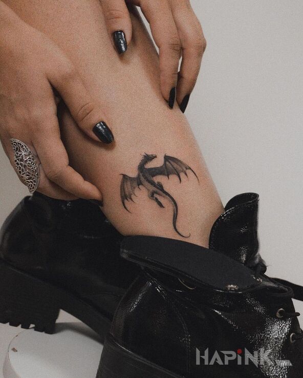 Tattoo Nieduży smok in black and gray motif and graphic / illustrative style on the leg