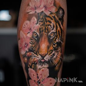 Tattoo Tiger on the leg motif: flowers style: realistic