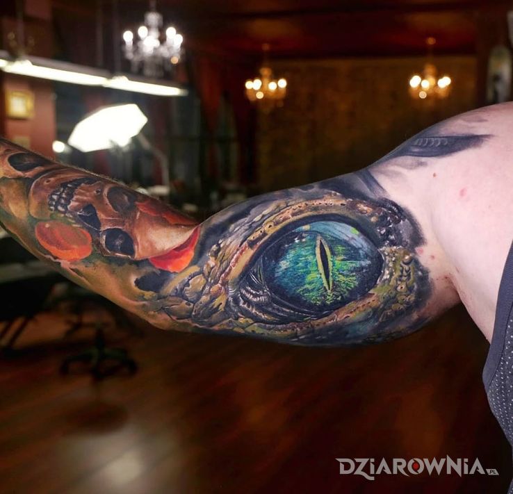 Tatuaż oko krokodyla w motywie czaszki i stylu realistyczne na ramieniu