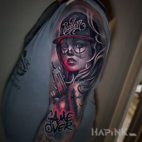 Tattoo Woman with a gun On the arm motif: lettering style: realistic