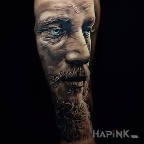 Tattoo Ragnar Lodbrok on the upper arm motif: faces style: realistic