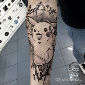 Tatuaż Pikachu - Pokemon "Feel the music" na przedramieniu motyw: czarno-szare styl: kreskówkowe / komiksowe
