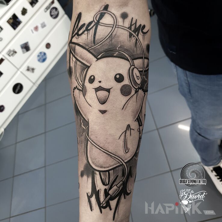 Tattoo Pikachu - Pokemon "Feel the music" in black and gray motif and cartoon / comic book style on the forearm