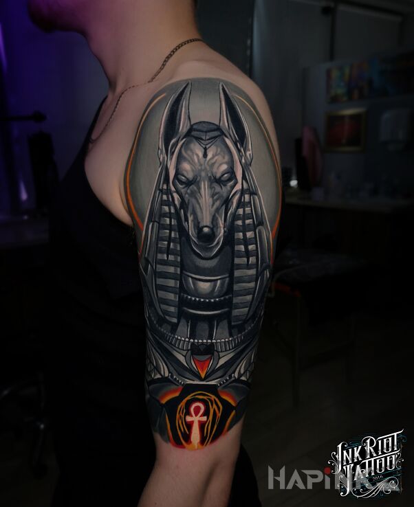Tattoo Anubis in characters motif and realistic style on the upper arm