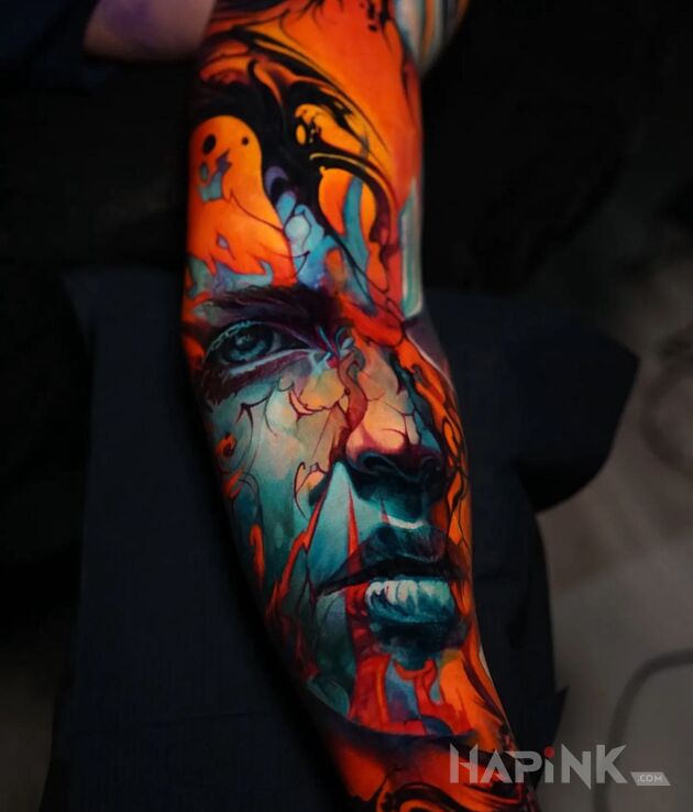 Tattoo Rozlana twarzyczka in colorful motif and abstract style on the forearm