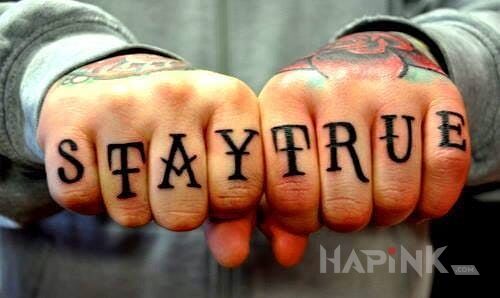 Tattoo Stay True in lettering motif on the fingers