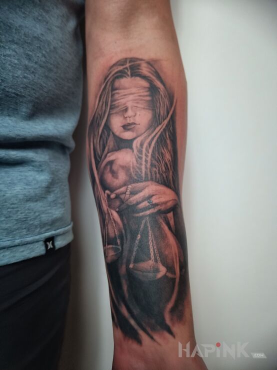 Tattoo Temida - ślepa sprawiedliwość in faces motif and realistic style on the forearm
