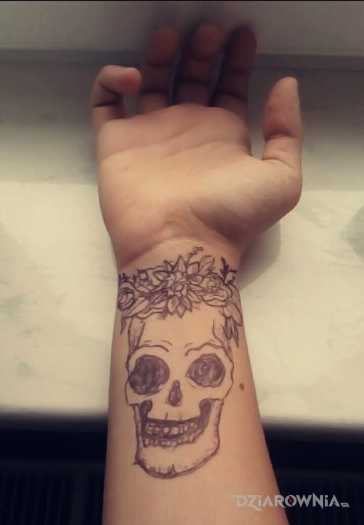 Tatuaż czaszka z kwiatami w motywie czaszki na przedramieniu