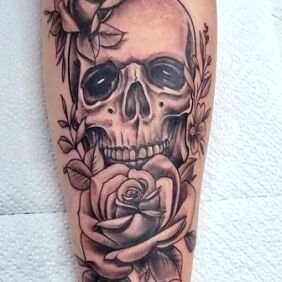 Tattoo Skull and roses On the arm motif: black and gray style: realistic