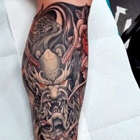 Tattoo Japanese demon on the forearm motif: black and gray style: japanese / irezumi