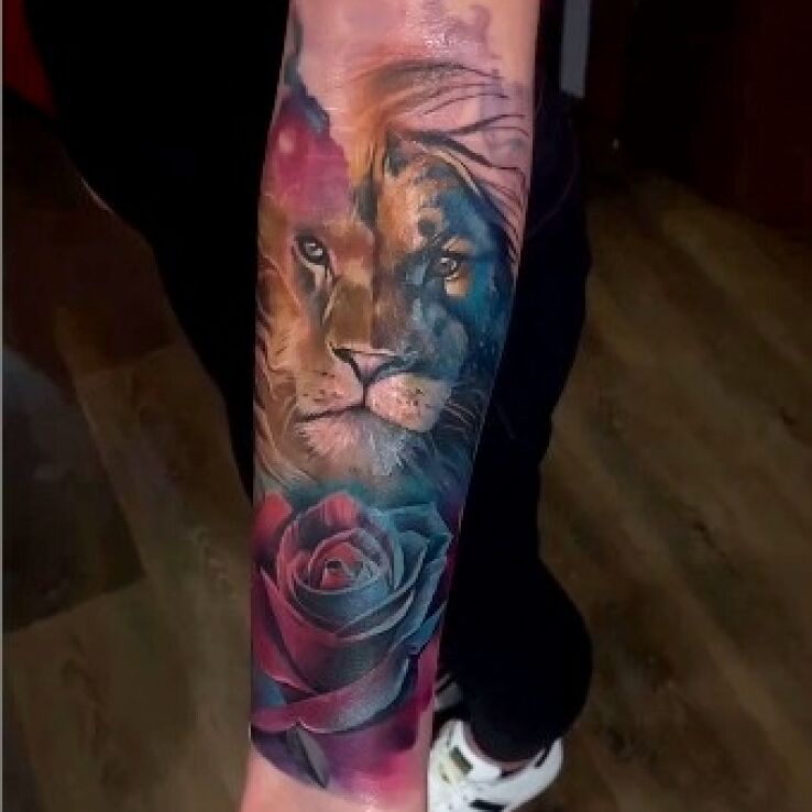 Tatuaż lew i róża w motywie znaki zodiaku i stylu realistyczne na przedramieniu