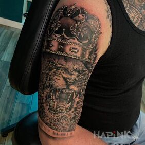 Tattoo Lion with a crown On the arm motif: black and gray style: realistic