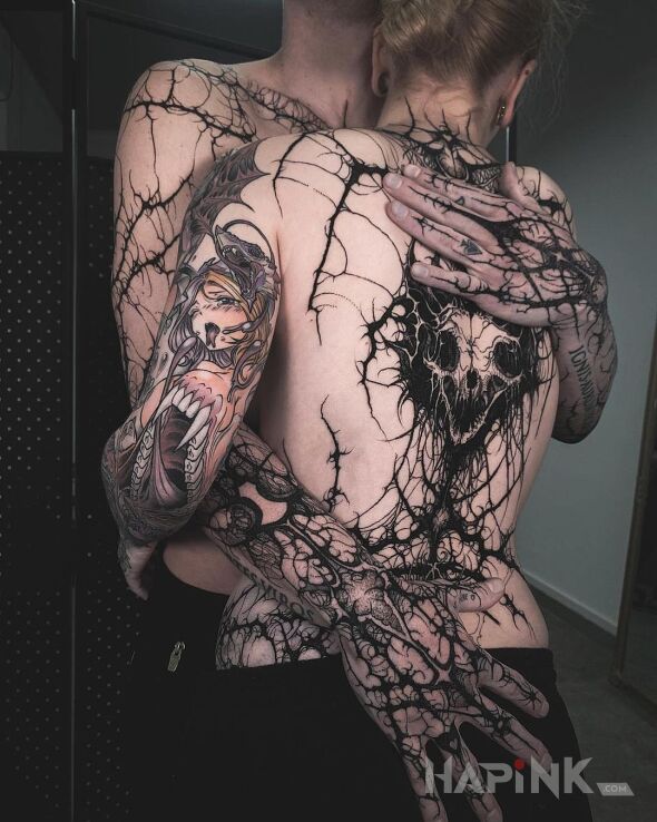 Tattoo W objęciach mroku in dark motif and blackwork / blackout style On the arm